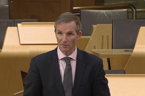 An image of Liam McArthur asking a question in the Scottish Parliament chamber